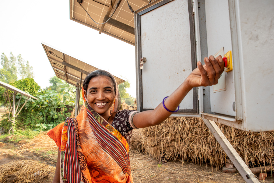 Indiase Reka bij de zonnepaneel die ze samen met andere gezinnen op afbetaling kocht