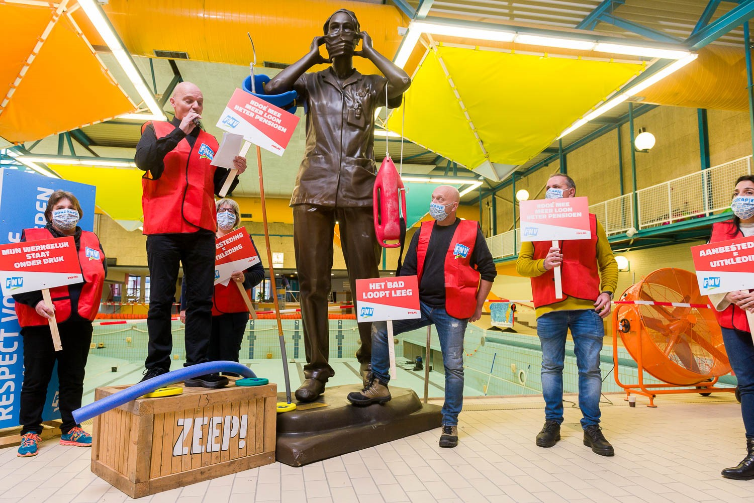 Zwembadmedewerkers met actiebordjes