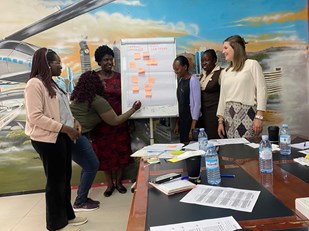 Pien Petter en de vrouwen die deelnemen aan het onderzoek in Oeganda staan bij een flapover