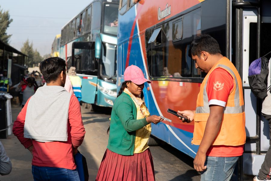 Vrouw staat voor ingang transportbus naar de blauwe bessen-plantage