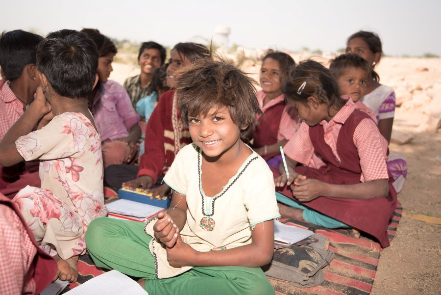 Schoolkinderen India zitten op de grond en krijgen onderwijs. Foto Roderick Polak